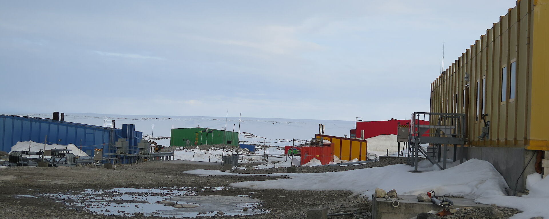 A daylight view of station buildings amongst snow and dirt, although it is 2300 (11pm)