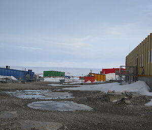 A daylight view of station buildings amongst snow and dirt, although it is 2300 (11pm)