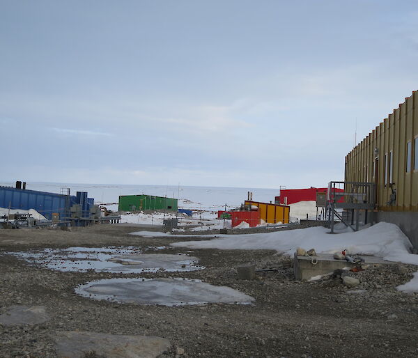 A daylight view of station buildings amongst snow and dirt, although it is 2300 (11pm)