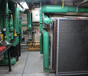 Cooling system in the emergency power house showing a large filter on right and thick pipes on the left