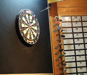 A dart board and score board next to it