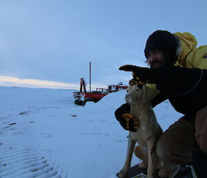 Expeditioner with Stay, the station mascot who is also a plastic guide dog.