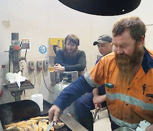 Expeditioners look on as BBQ is cooked