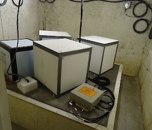 Four white boxes and a metal control box — equipment inside the seismic vault