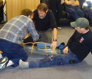 Men practice applying first aid to a leg