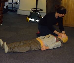 Expeditioners surround a medical dummy on the floor