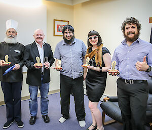 Five expeditioners stand proudly displaying their ‘Golden Thong’ awards.