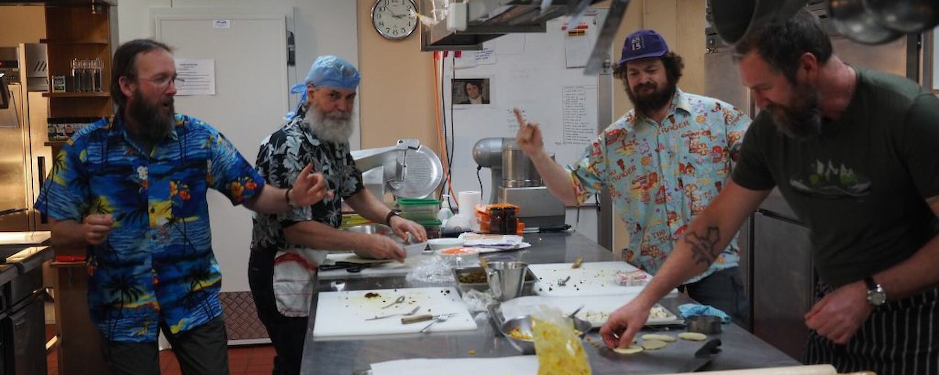 Four male expeditioners in kitchen preparing Indian feast