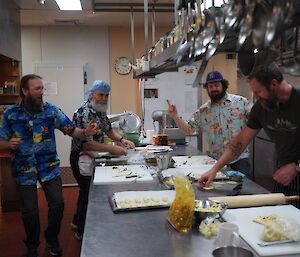 Four male expeditioners in kitchen preparing Indian feast