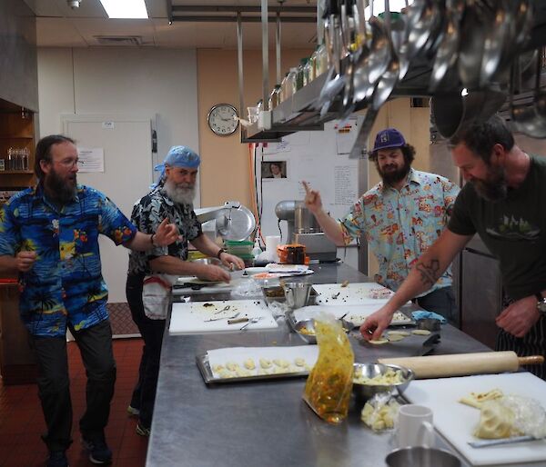 Four male expeditioners in kitchen preparing Indian feast
