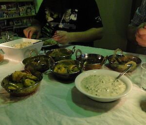 Selection of curries for competition laid out in small metal, Indian style bowls.