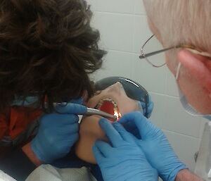 Expeditioners practicing dentistry on a dummy
