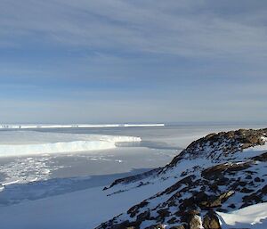 The view over a part of the Vanderford Glacier with rocks on right and sea and ice on left
