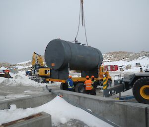 Crane lowers tank onto truck