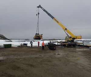 Large machinery is lifted onto barge