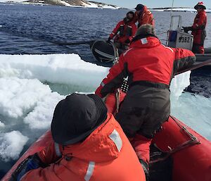 Expeditioners on boats maneuver the fuel hose and check for leaks.