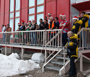 Expeditioners greet Santa at front of red shed