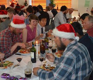 A dining room full of people at rectangular tables, many of them dressed for the occasion
