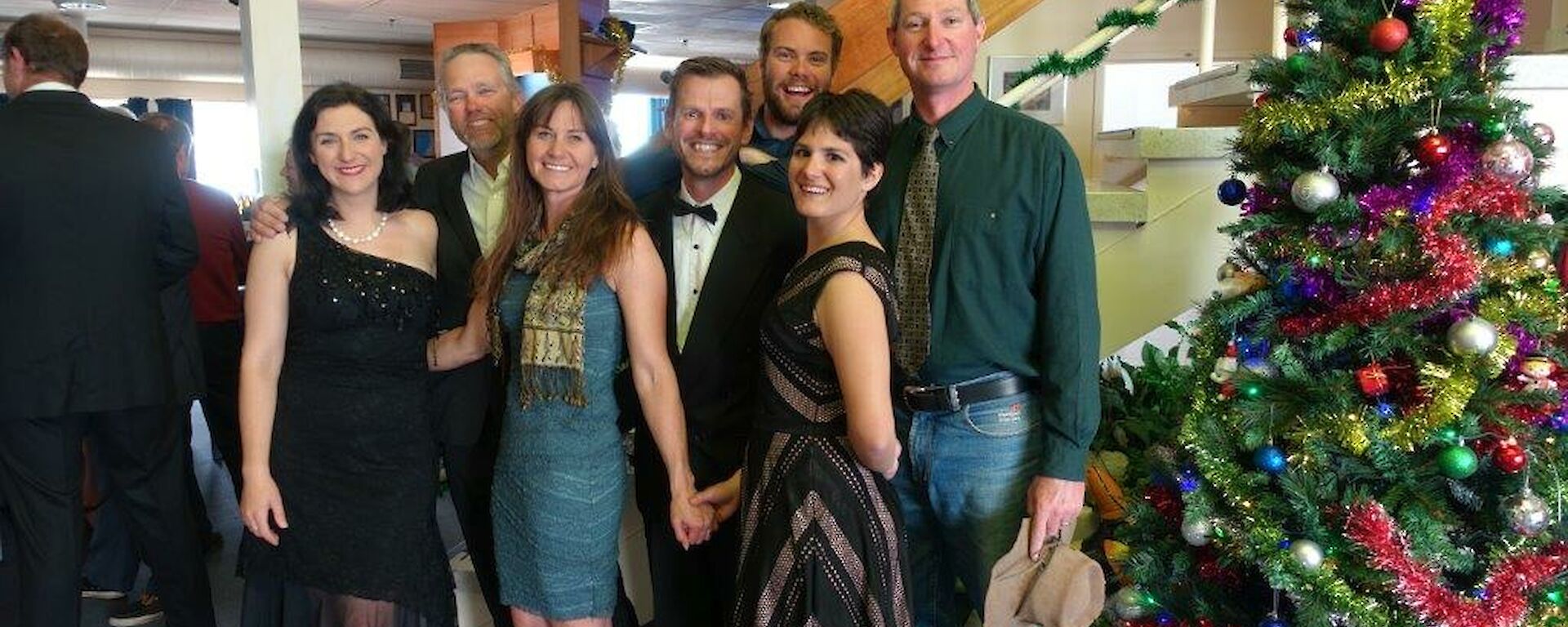 Three women and four men dressed up for a Christmas party