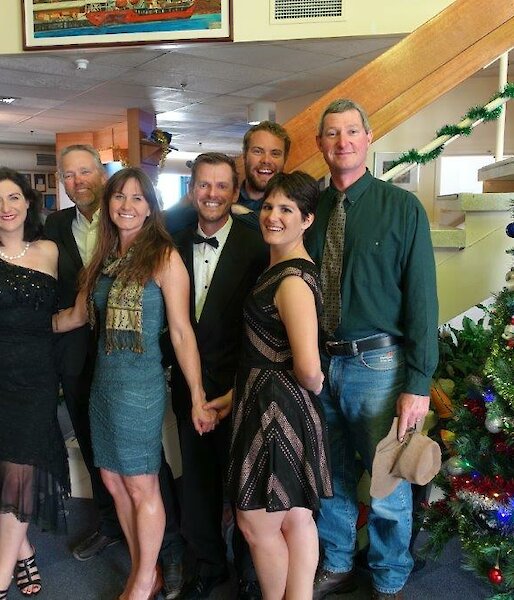 Three women and four men dressed up for a Christmas party
