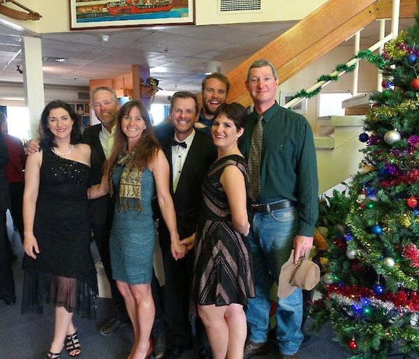 Three women and four men dressed up for a Christmas party