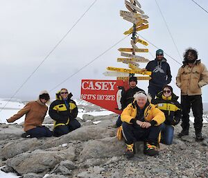 A group photo of men and women outside at the Casey station direction sign