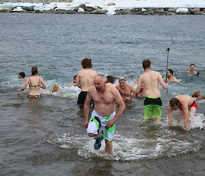 Expeditioners exit the water after summer swim with shocked expressions on their faces.