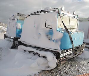 Hägglunds tracked vehicle covered in snow after blizzard