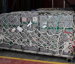 Cargo wrapped up in netting and sitting inside a shipping container