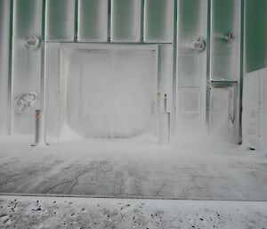 A storage building’s external wall and entrance covered in frost, or blizz