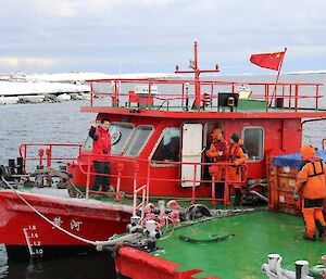 The Chinese barge crew showing one expeditioner waving to the camera and three in full gear working