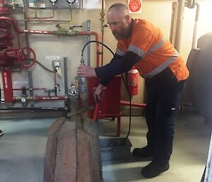 Cameron pressure testing the repaired melt bell with a water pressure testing bucket.