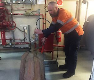 Cameron pressure testing the repaired melt bell with a water pressure testing bucket.