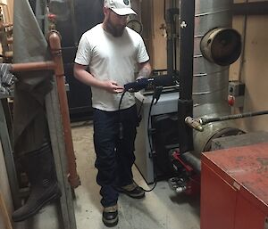 Jimmy conducting maintenance checks on the workshop heating boilers holding the flu gas analyser equipment.