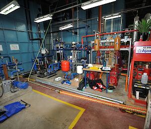 Looking at the potable and fire pump sets and piping in the tank house with the blue 90k tanks in the background.