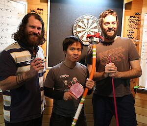 Individual winners of the darts, table tennis and pool competitions standing in front of the dart board for the winners photo.