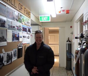 Donna standing in the passage of the science building with a big smile on her face.