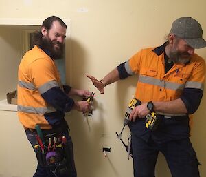 Adam joking he will cut the red wire with a pair of pliers with Michael looking away pretending to be horrified.