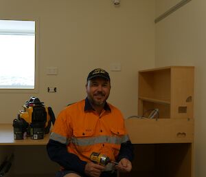 Danny working on the new donga furniture installation with a battery drill in his hand for screwing it all together.