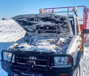 The Toyota Ute with the bonnet up showing every little bit of space full of snow after a blizzard.