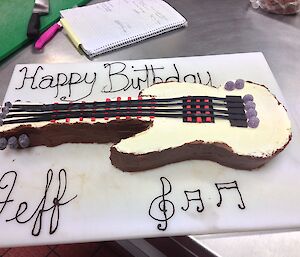 Birthday Cake made in the shape of a guitar.