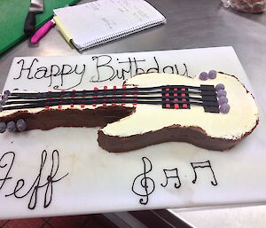 Birthday Cake made in the shape of a guitar.