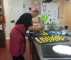 Chef Donna piping out meringues on to oven trays.