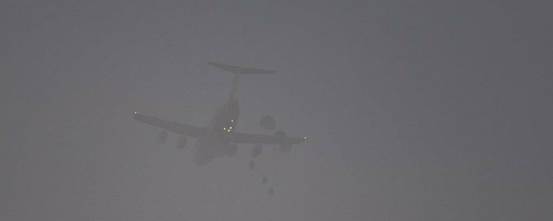 Three parachutes open as the parcels are dropped from the C-17.