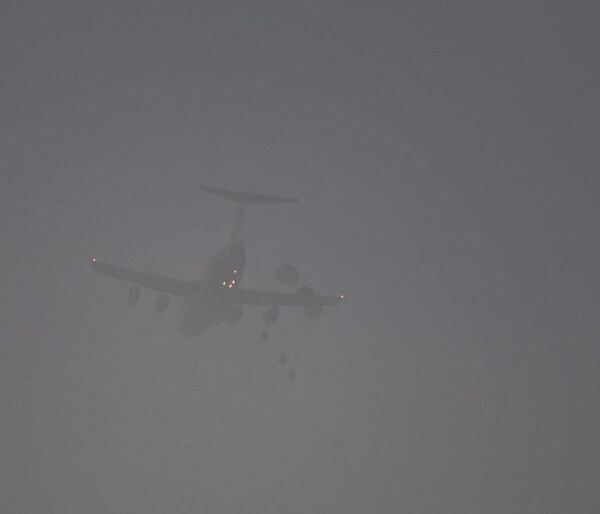 Three parachutes open as the parcels are dropped from the C-17.