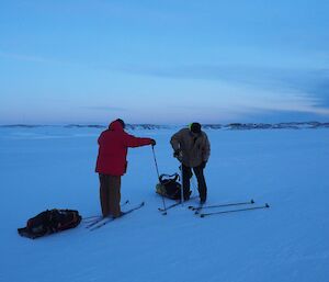 Drilling the sea ice to check its thickness during a cross-country ski trip.