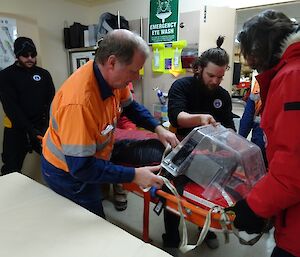 SAR team removing the head protection cover of the stretcher once in the medial rooms.