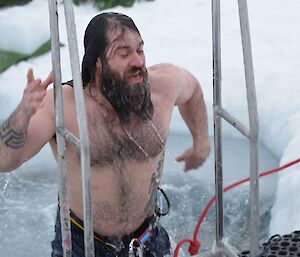 Adam climbing up the ladder out of the sea ice hole after having a very quick dip.