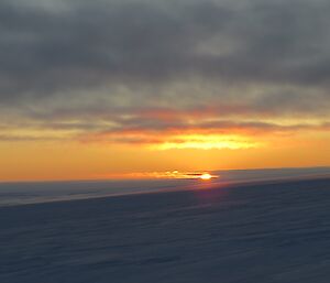 The sun disappearing below the horizon with bright reflection on the cloud cover taken from Jack’s hut.