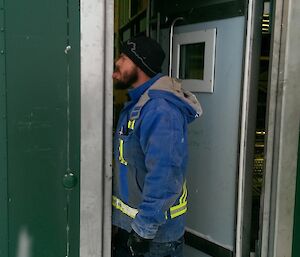 Expeditioner having some fun pretending to have his tongue stuck the steel frame on the external door.